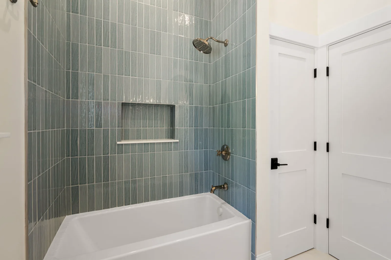 Guest bath with sage green tiled tub and shower