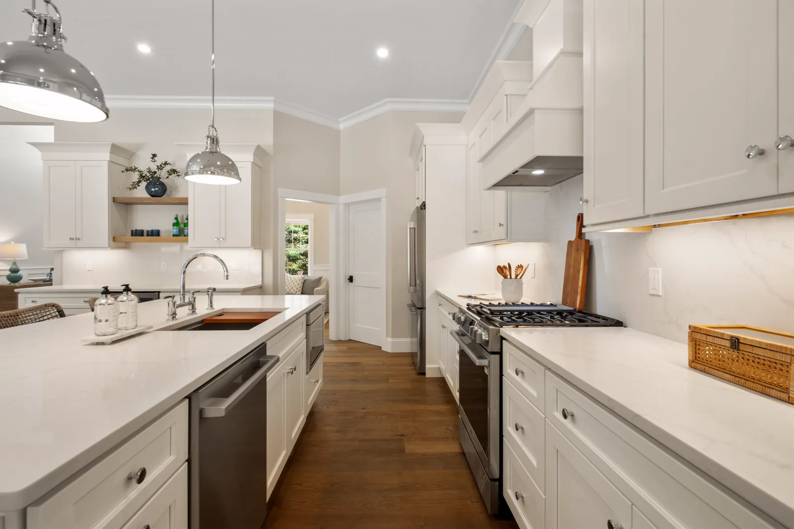 Gas range and quartz counters with custom white cabinetry