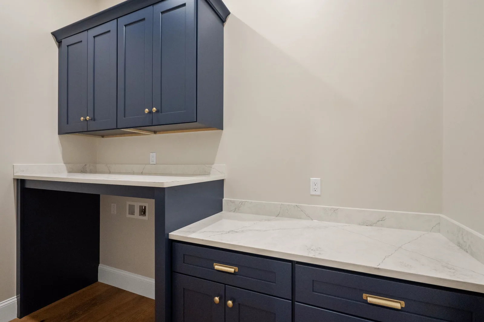 Laundry room with navy cabinets and brass hardware