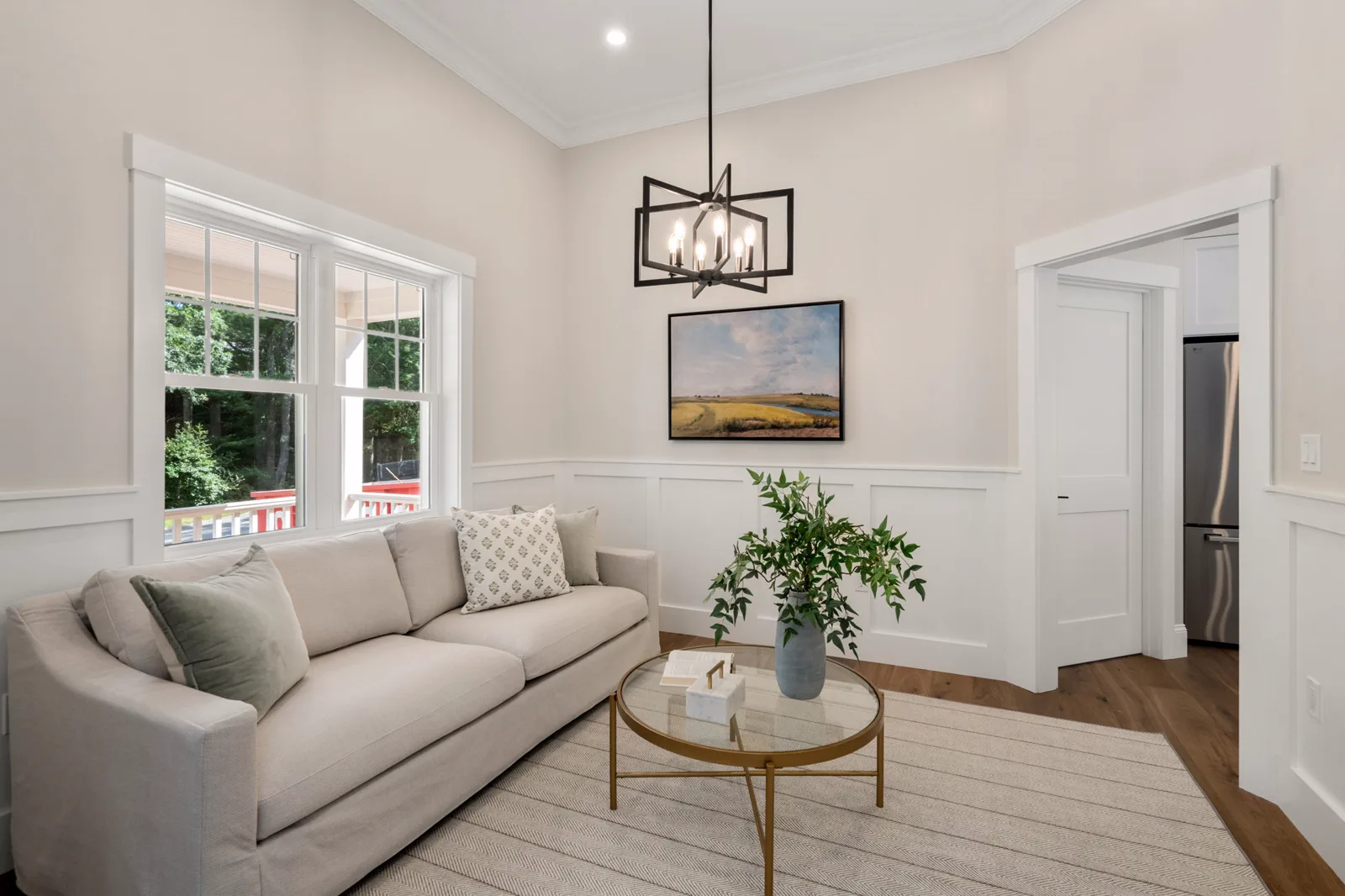 Sitting area with sofa beneath a black lantern chandelier